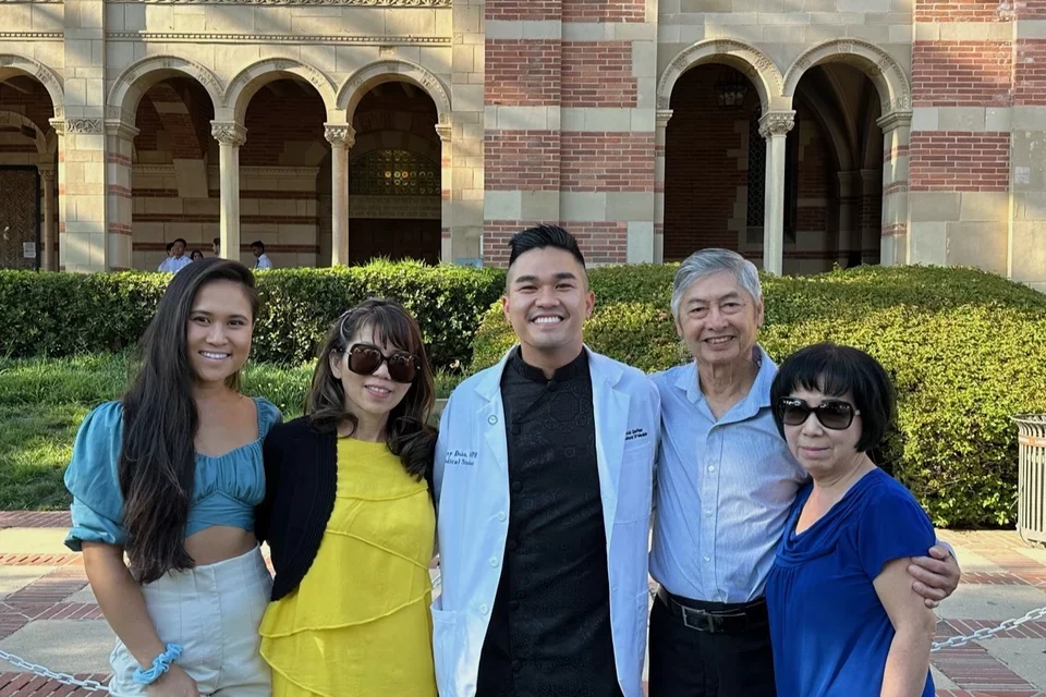 First-general medical student Danny Đoàn, pictured with his family in front of a UCLA academic building. 